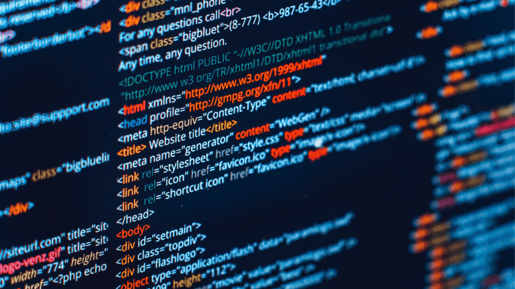 Close-up of computer screen showing colorful HTML and structured code syntax on a dark editor background.